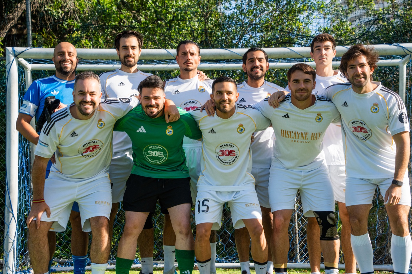 A corporate team arm-in-arm in front of the goal at an FCnoise corporate experience
