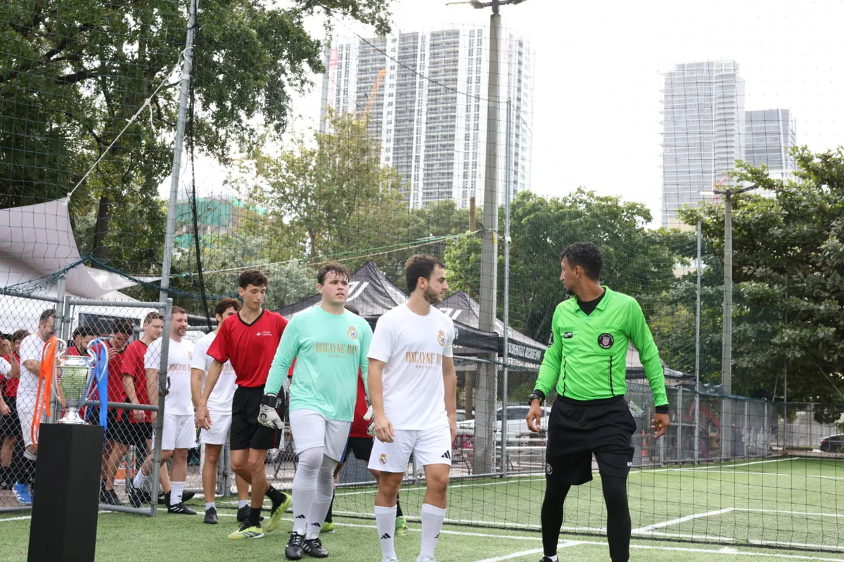 Teams and referee walking out past the trophy before a CFL corporate soccer match in Miami